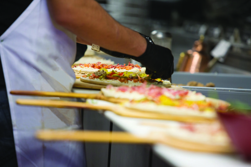 Firo pizzas being topped by a Firo-ista